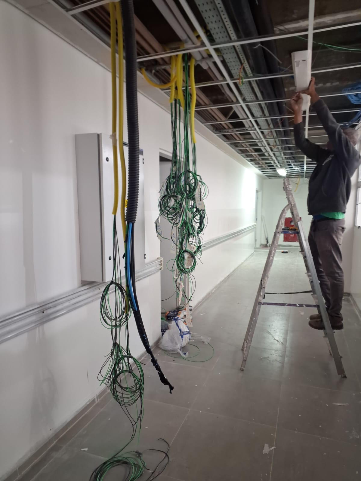 Instalação elétrica em ambiente interno com profissional em campo